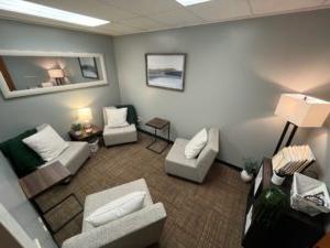 four grey chairs with pillows in a small room